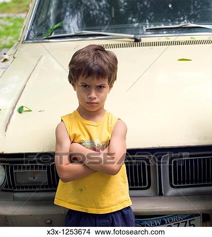 Picture - An upset child leaning on a car. Fotosearch
