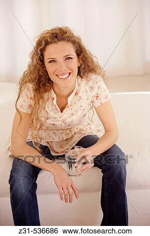 Angela, Couch, Sitting, Smiling, Glass water View Large Photo Image Stock Photograph - Angela, Couch, Sitting, Smiling, Glass water. Fotosearch