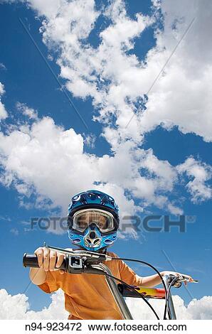 Stock Image - Angle shot of a child equipped for competition with a moped.. Fotosearch