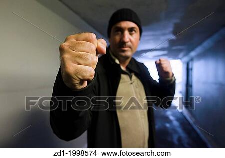 Angry man punching in a street fight. View Large Photo Image Picture - Angry man punching in a street fight.. Fotosearch