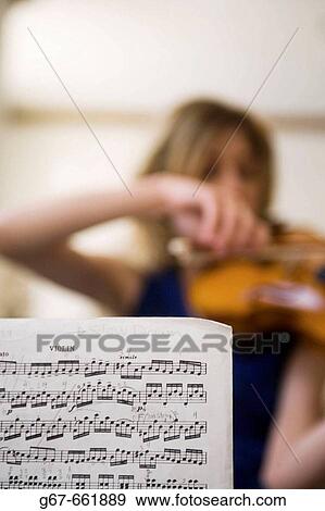 Annotated sheet music for violin in foreground with young woman, de-focused playing violin in background View Large Photo Image Stock Photo - Annotated sheet music for violin in foreground with young woman, de-focused playing violin in background. Fotosearch
