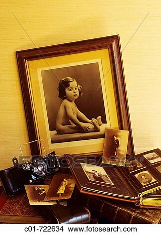 Antique photo of a baby and picture album with family portraits (19th century) and ancient folding camera View Large Photo Image Picture - Antique photo of a baby and picture album with family portraits (19th century) and ancient folding camera. Fotosearch