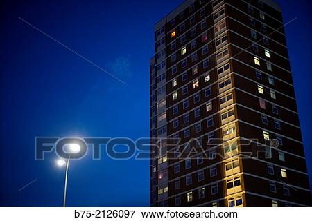 Apartment building at dusk with lights on in some windows and a street lamp in the foreground. London, England, UK View Large Photo Image Stock Photo - Apartment building at dusk with lights on in some windows and a street lamp in the foreground. London, England, UK. Fotosearch