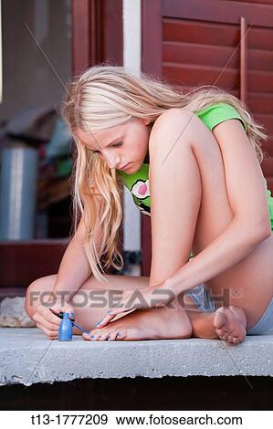 Stock Photo - Applying a foot nail paint. Fotosearch