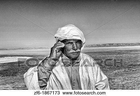 Arab man on cell phone Great Dry Salt Lake Chott el Jerid in Sahara Desert sand near Douz in Tunisia isolated Africa View Large Photo Image Stock Image - Arab man on cell phone Great Dry Salt Lake Chott el Jerid in Sahara Desert sand near Douz in Tunisia isolated Africa. Fotosearch