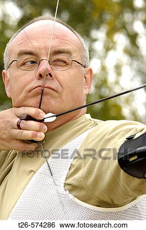 Archery man sighting before the shot View Large Photo Image Stock Photograph - Archery man sighting before the shot. Fotosearch