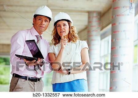 Architect and client with tablet PC in construction site View Large Photo Image Stock Photo - Architect and client with tablet PC in construction site. Fotosearch