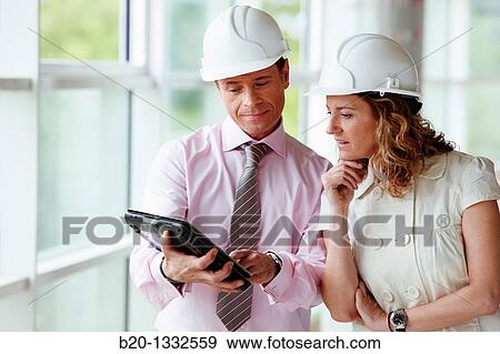 Architect and client with tablet PC in construction site View Large Photo Image Stock Photo - Architect and client with tablet PC in construction site. Fotosearch