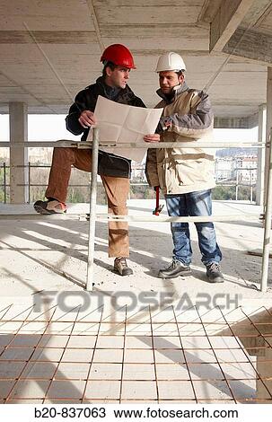 Architect and construction worker looking at blueprints, personal protective equipment, housing construction, concrete skeleton View Large Photo Image Stock Image - Architect and construction worker looking at blueprints, personal protective equipment, housing construction, concrete skeleton. Fotosearch