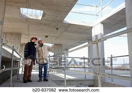 Stock Image - Architect and construction worker, personal protective equipment, housing construction, concrete skeleton. Fotosearch