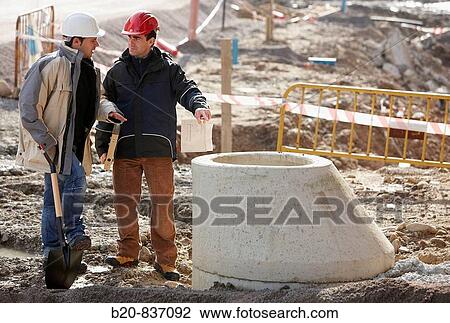 Stock Image - Architect and construction worker, personal protective equipment, water meter, urbanization. Fotosearch