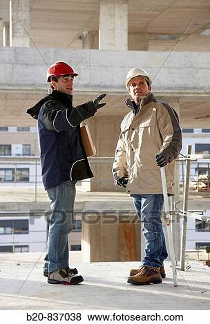 Architect and construction worker, personal protective equipment, housing construction, concrete skeleton View Large Photo Image Stock Photo - Architect and construction worker, personal protective equipment, housing construction, concrete skeleton. Fotosearch