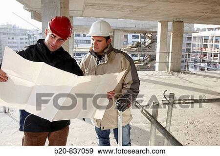 Architect and construction worker looking at blueprints, personal protective equipment, housing construction, concrete skeleton View Large Photo Image Stock Photo - Architect and construction worker looking at blueprints, personal protective equipment, housing construction, concrete skeleton. Fotosearch