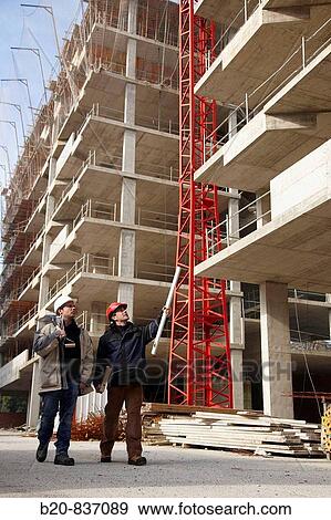 Architect and construction worker, personal protective equipment, housing construction, concrete skeleton View Large Photo Image Stock Photo - Architect and construction worker, personal protective equipment, housing construction, concrete skeleton. Fotosearch