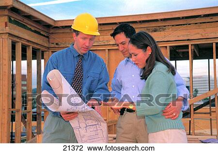 Architect discusses plans for home under construction with hispanic couple View Large Photo Image Stock Image - Architect discusses plans for home under construction with hispanic couple. Fotosearch