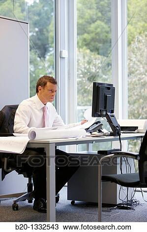 Architect with blueprints in office View Large Photo Image Stock Image - Architect with blueprints in office. Fotosearch