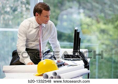 Architect with blueprints in office View Large Photo Image Stock Photo - Architect with blueprints in office. Fotosearch