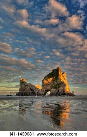 Archway Islands, sunrise lights up high clouds, Wharariki beach, near Collingwood, Golden Bay, New Zealand View Large Photo Image Stock Image - Archway Islands, sunrise lights up high clouds, Wharariki beach, near Collingwood, Golden Bay, New Zealand. Fotosearch