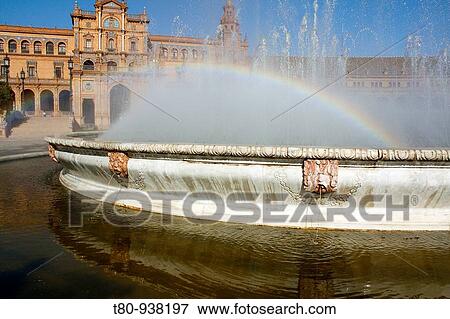 Stock Photo - Arco iris por el agua pulverizada por la fuenta de la plaza de Espaa en Sevilla, Espaa. Rainbow by the spray of the fountain in the square of Spain in Seville, Spain.. Fotosearch