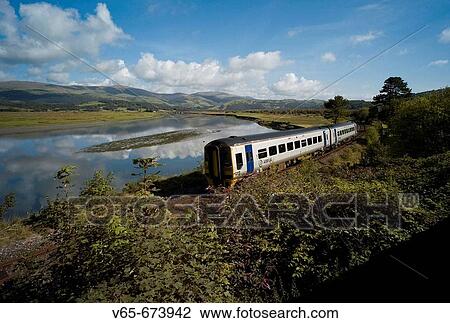 Arriva Trains Wales diesel train at Dovey Junction near Machynlleth Powys, with the Dyfi River behind and the hills and mountains of Snowdonia National Park in the distance View Large Photo Image Stock Image - Arriva Trains Wales diesel train at Dovey Junction near Machynlleth Powys, with the Dyfi River behind and the hills and mountains of Snowdonia National Park in the distance. Fotosearch