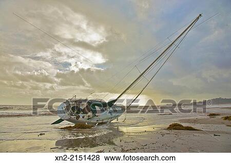 As the storm that ran it aground clears, a sailboat lies high and dry on East Beach, Santa Barbara, California, United States View Large Photo Image Stock Photo - As the storm that ran it aground clears, a sailboat lies high and dry on East Beach, Santa Barbara, California, United States. Fotosearch