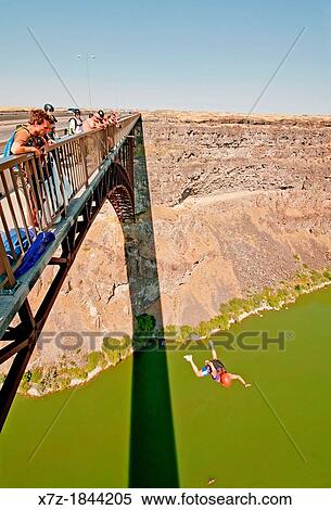 Stock Photography - Ashly Gillis BASE jumping at the Perrine Memorial Bridge over the Snake River Canyon near the city of Twin Falls in southern Idaho. Fotosearch