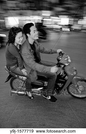 Asia, Vietnam, Hanoi Hanoi old quarter Young couple on motorbike rushing through the traffic View Large Photo Image Stock Photo - Asia, Vietnam, Hanoi Hanoi old quarter Young couple on motorbike rushing through the traffic. Fotosearch