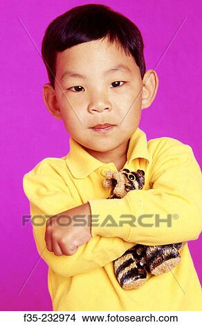 Picture - Asian American Boy Holding Stuffed Animal. Fotosearch