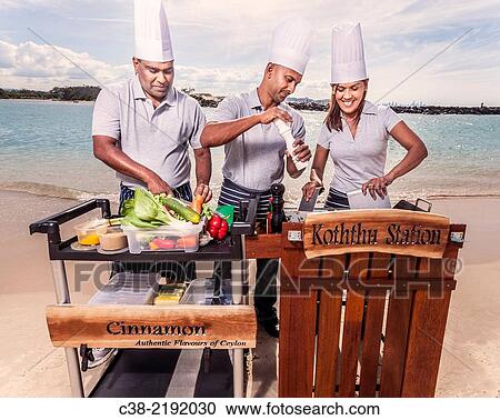 Stock Image - Asian catering chefs at the beach cooking with a Koththu station. Gold Coast, Queensland, Australia.. Fotosearch