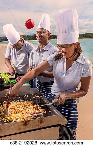 Stock Photo - Asian catering chefs at the beach cooking with a Koththu station. Gold Coast, Queensland, Australia.. Fotosearch