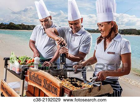 Stock Photo - Asian catering chefs at the beach cooking with a Koththu station. Gold Coast, Queensland, Australia.. Fotosearch