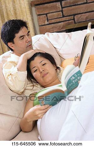 Asian couple in their 30's reading together peacefully and spending time together enjoying the company of each other View Large Photo Image Stock Photograph - Asian couple in their 30's reading together peacefully and spending time together enjoying the company of each other. Fotosearch