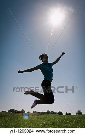 Asian girl jumping in a field during summer. Shot in Aachen, Germany. View Large Photo Image Picture - Asian girl jumping in a field during summer. Shot in Aachen, Germany.. Fotosearch