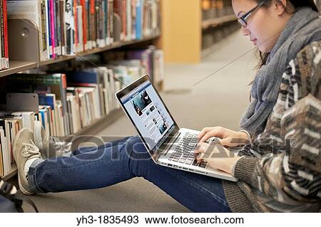 Asian girl logging in to her Facebook account with her laptop at a library View Large Photo Image Stock Image - Asian girl logging in to her Facebook account with her laptop at a library. Fotosearch