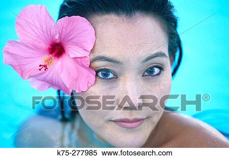 Asian girl with hibiscus flower in hair View Large Photo Image Stock Photography - Asian girl with hibiscus flower in hair. Fotosearch
