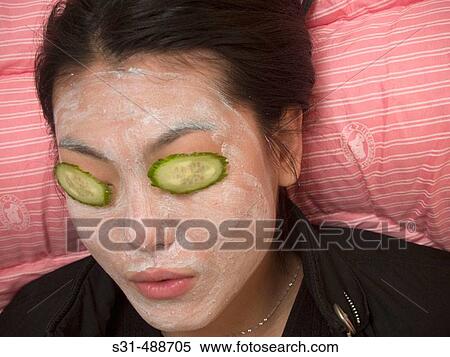 Asian girl(s) with face masks and slices of cucumbers on their eyes as in beauty treatment View Large Photo Image Stock Photography - Asian girl(s) with face masks and slices of cucumbers on their eyes as in beauty treatment. Fotosearch
