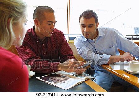 Asian male using cell phone, showing others his phone View Large Photo Image Stock Image - Asian male using cell phone, showing others his phone. Fotosearch