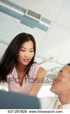 Asian man and woman working at computer in contemporary office View Large Photo Image Stock Photo - Asian man and woman working at computer in contemporary office. Fotosearch