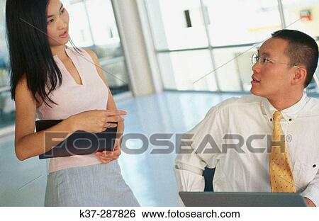 Asian man and woman working at computer in contemporary office View Large Photo Image Stock Photograph - Asian man and woman working at computer in contemporary office. Fotosearch