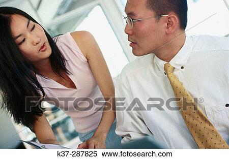 Asian man and woman working at computer in contemporary office View Large Photo Image Stock Photography - Asian man and woman working at computer in contemporary office. Fotosearch