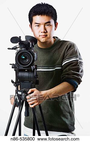 Stock Image - Asian man with video camera. Fotosearch