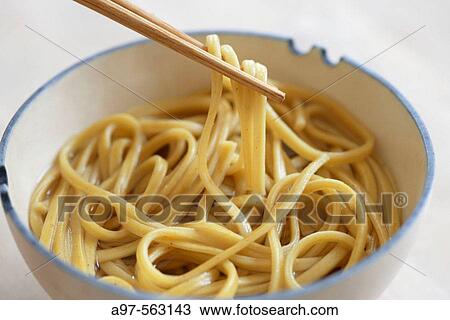 Asian noodles being lifted from a bowl by chopsticks. View Large Photo Image Stock Image - Asian noodles being lifted from a bowl by chopsticks.. Fotosearch