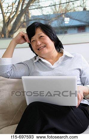 Stock Image - Asian woman day dreaming. Fotosearch