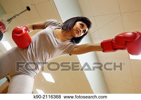 Asian woman doing boxing exercises with a big red gloves, Jakarta, Indonesia, Southeast Asia. View Large Photo Image Stock Photo - Asian woman doing boxing exercises with a big red gloves, Jakarta, Indonesia, Southeast Asia.. Fotosearch