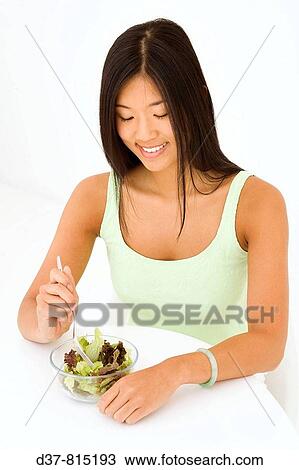 Asian woman eating a green salad View Large Photo Image Stock Image - Asian woman eating a green salad. Fotosearch
