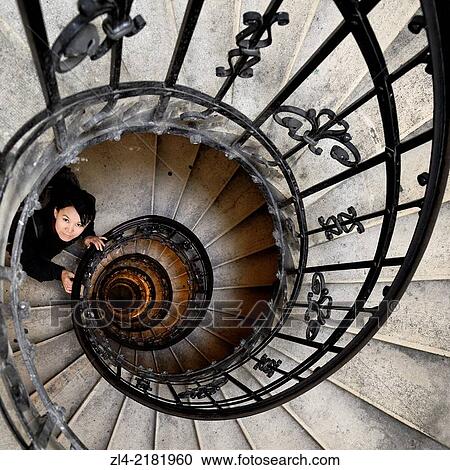 Stock Image - Asian woman in the spiral (helical) staircase in the tower of the Basilica of St Stephen. Hungary, Budapest, Pest, Belvaros. Model Released.. Fotosearch