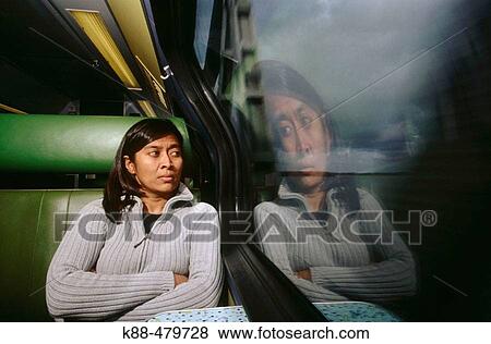 Stock Photo - Asian woman on commuter train. Fotosearch