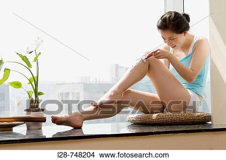 Asian woman shaving her legs View Large Photo Image Picture - Asian woman shaving her legs. Fotosearch