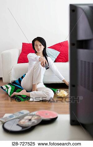 Stock Photography - Asian woman watching television. Fotosearch