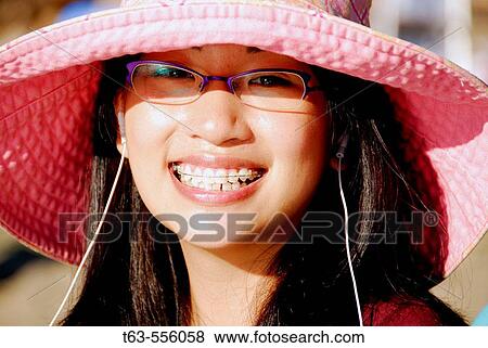 asian young woman smiling with music earphones in ears View Large Photo Image Stock Photo - asian young woman smiling with music earphones in ears. Fotosearch